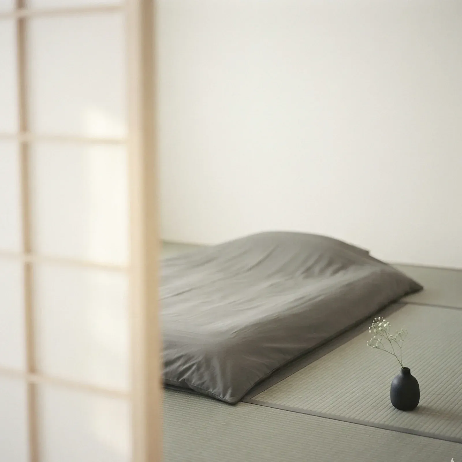 障子と畳の和室。中央に平らに敷かれた絹灰の真絲布団。柔和な朝日が障子越しに差し込む。
